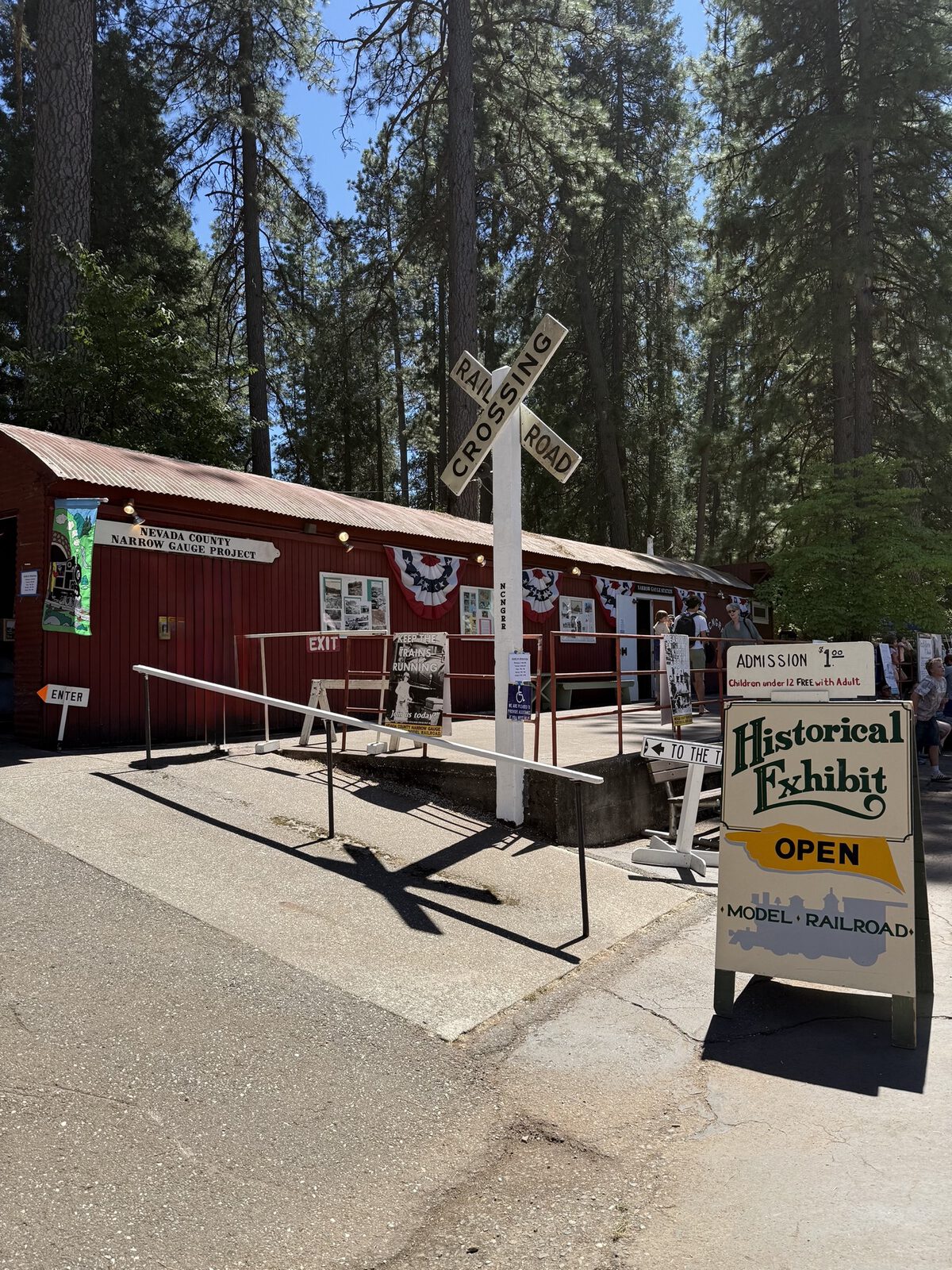 N.C.N.G. Historical Model Railroad building at the Nevada County Fairgrounds with Railroad Crossing sign and Historical Exhibit Open sandwich board