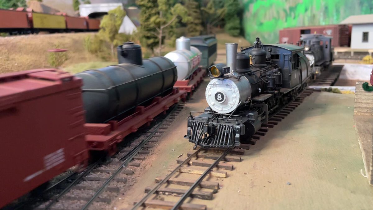 Engine #8 hauling freight cars past the yard