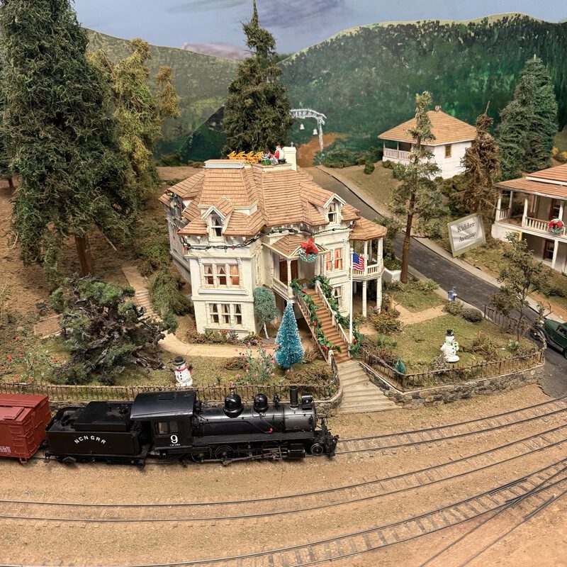 Engine #9 passing the Kidder house with Christmas decorations and snowmen