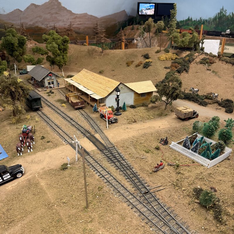 Colfax depot with railroad crossing, Christmas tree lot, and horse riders