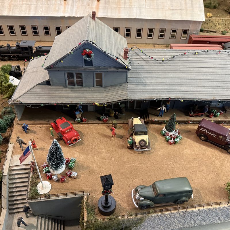 Town scene with Christmas decorations, vintage cars, and JCPenney delivery van