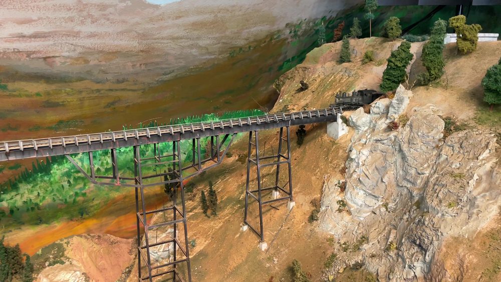 Locomotive approaching the Bear River Bridge trestle through mountain scenery